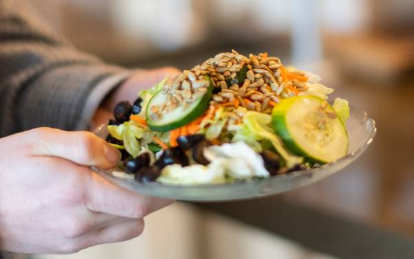 Hands holding a salad at Fresh Food Co.